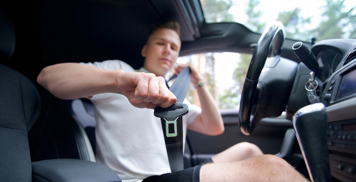 Jeune conducteur en période probatoire effectuant une vérification de sécurité de son véhicule avant de prendre la route
